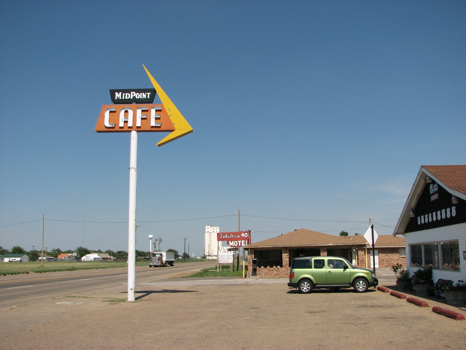 The MidPoint Cafe sign on a tall pole beside old Route 66 in Adrian, Texas