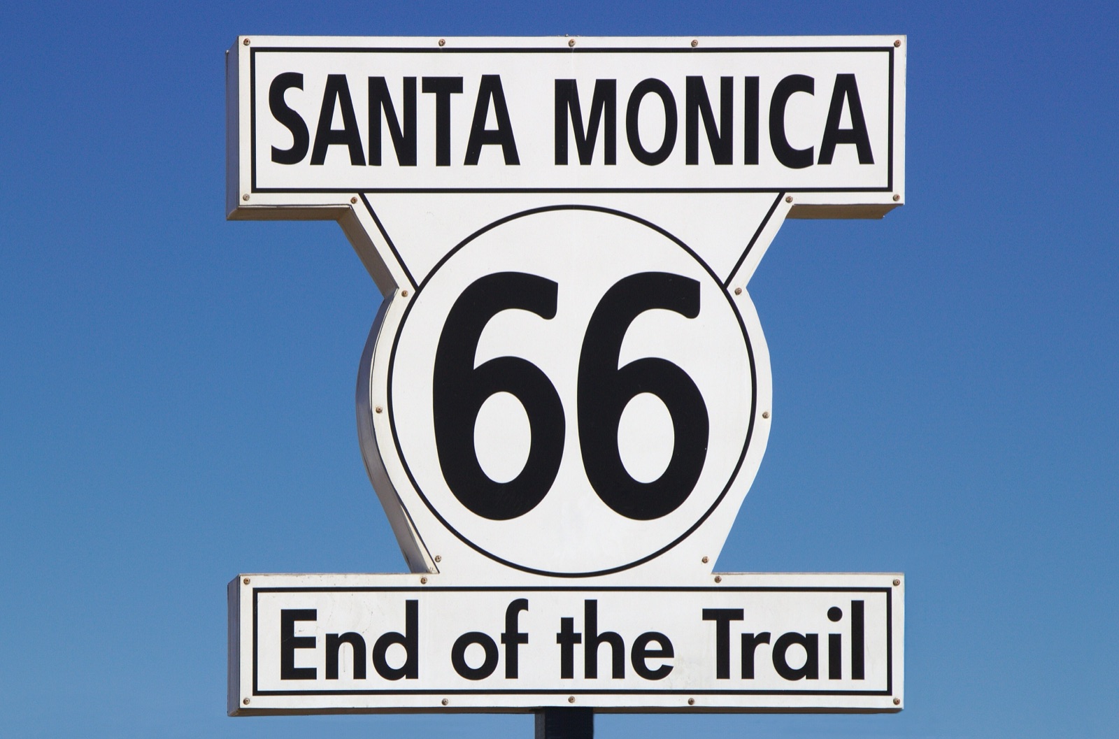Santa Monica 66 End of the Trail sign against a clear blue sky