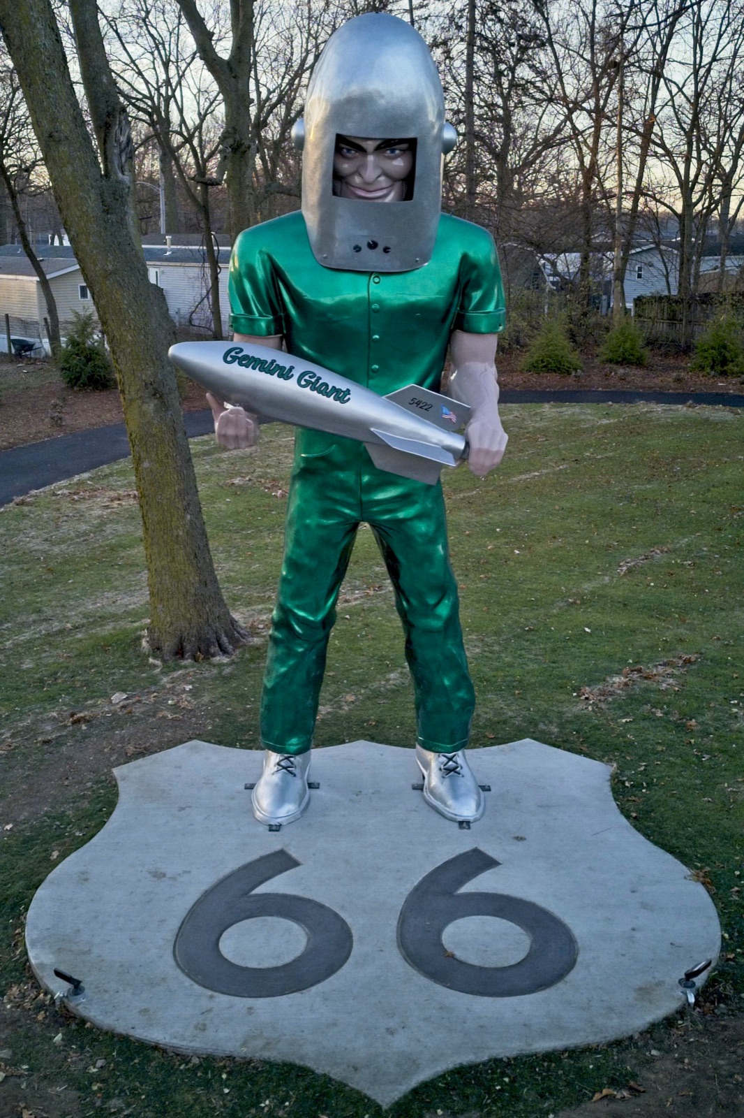 The Gemini Giant, a tall green fiberglass astronaut holding a rocket, standing on a Route 66 shield base in a park in Wilmington, Illinois