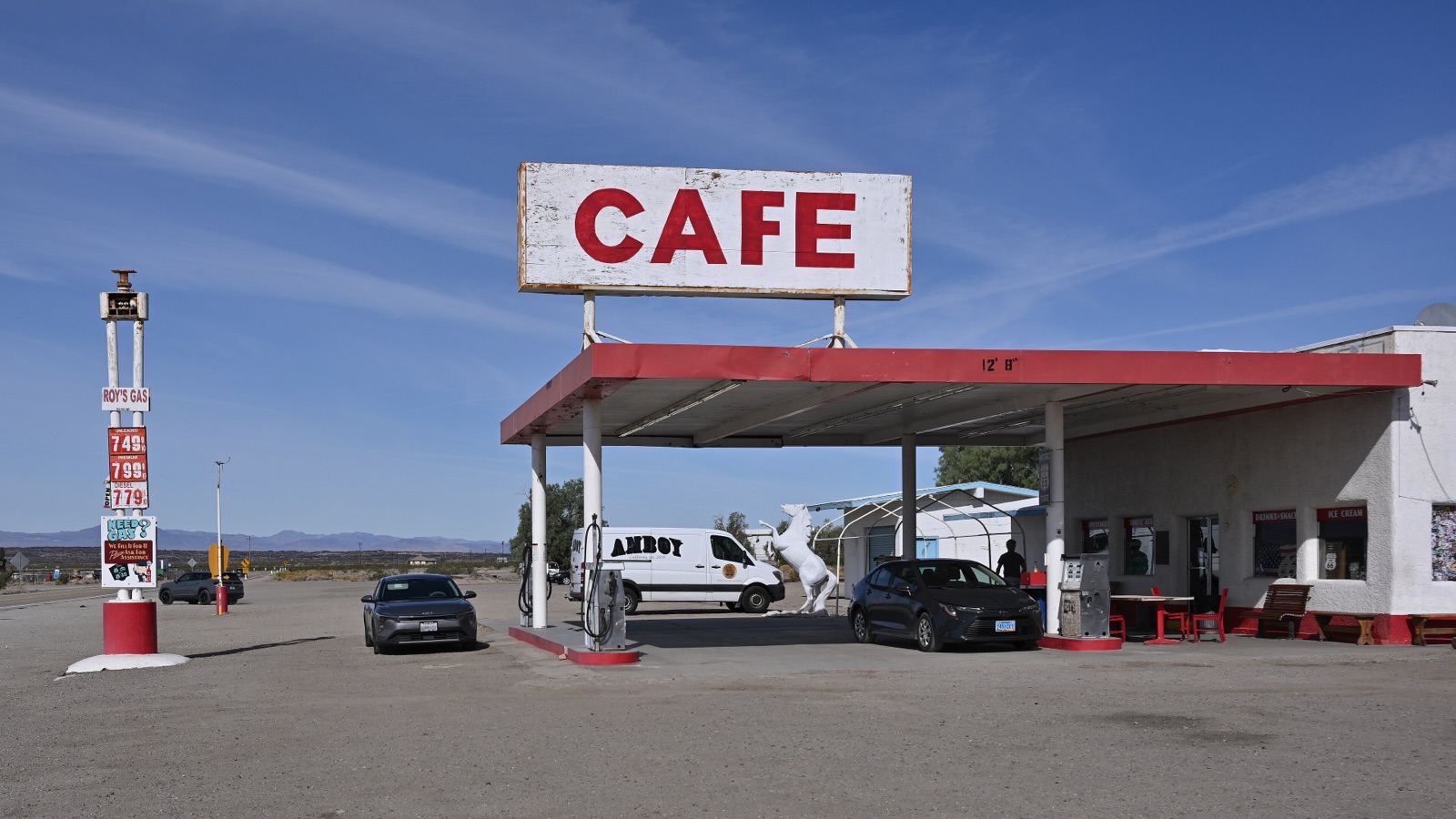 Roy's Cafe in Amboy, California, with its tall CAFE sign over the fuel canopy and the desert behind